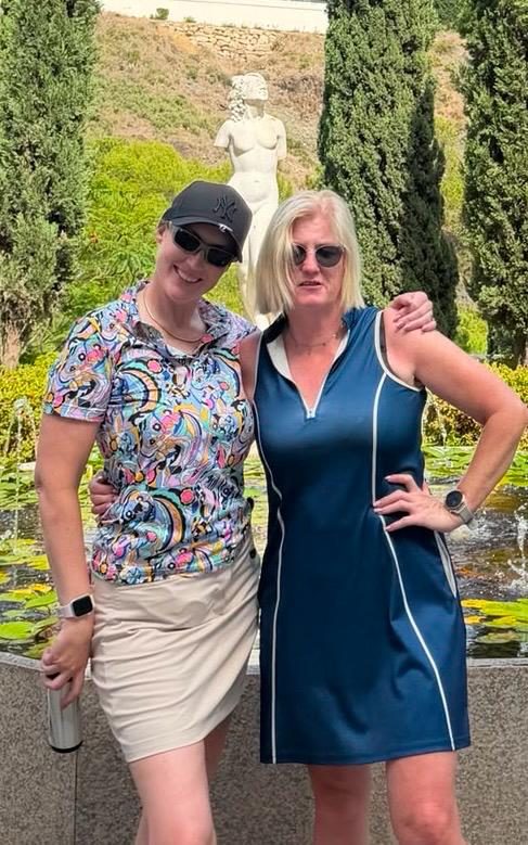 Two society members by a garden fountain